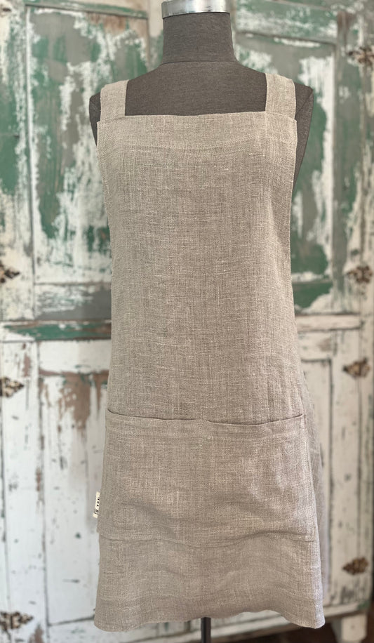 A dressmaker's Judy displays the linen crossback apron with two pockets. A vintage green and white cabinet stands in the background.