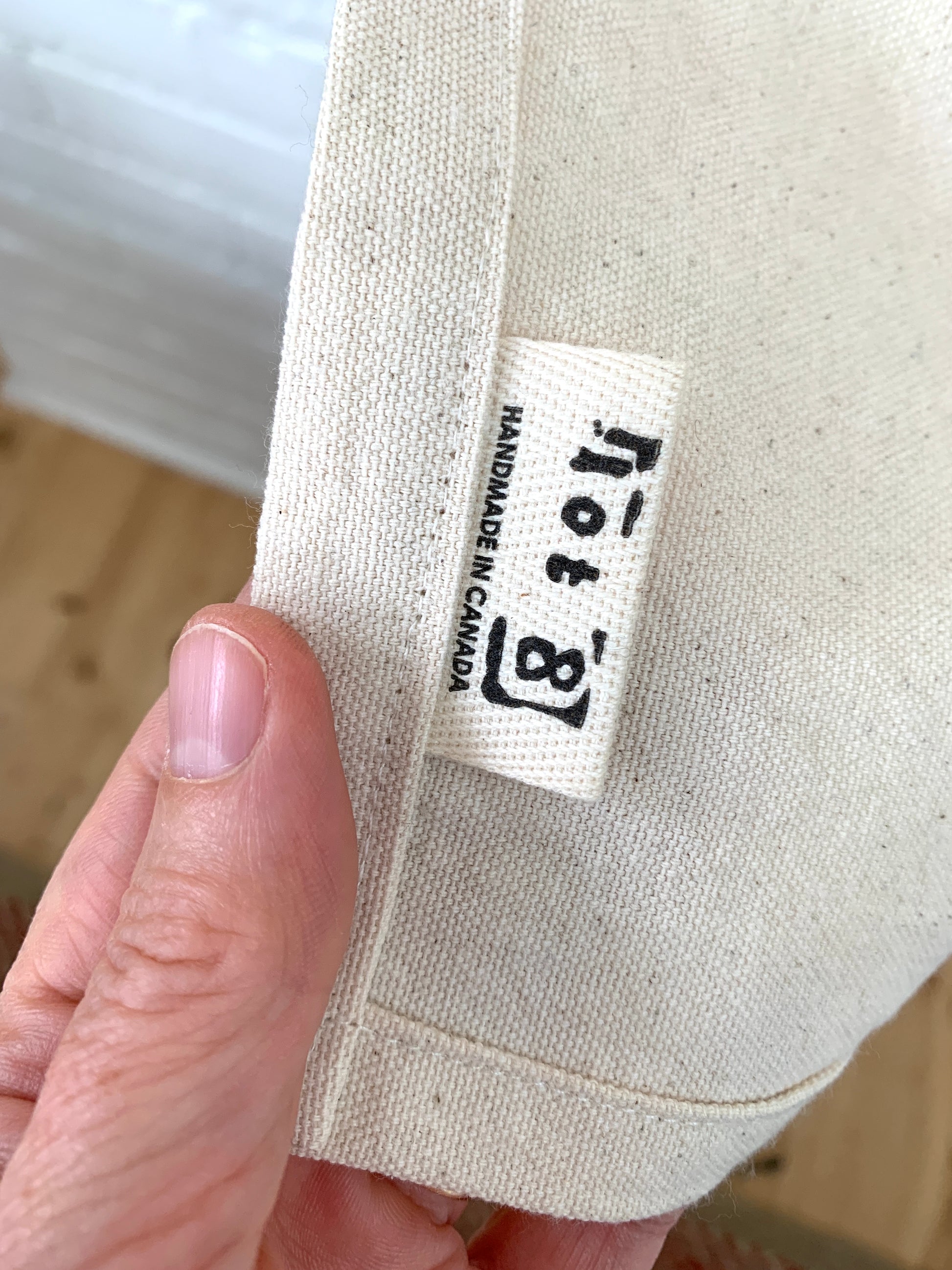 Close up of lot8 twill tag sewn into seam of apron