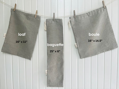 Three natural linen bread bags labeled 'loaf', 'baguette', and 'boule' with dimensions on a white background.