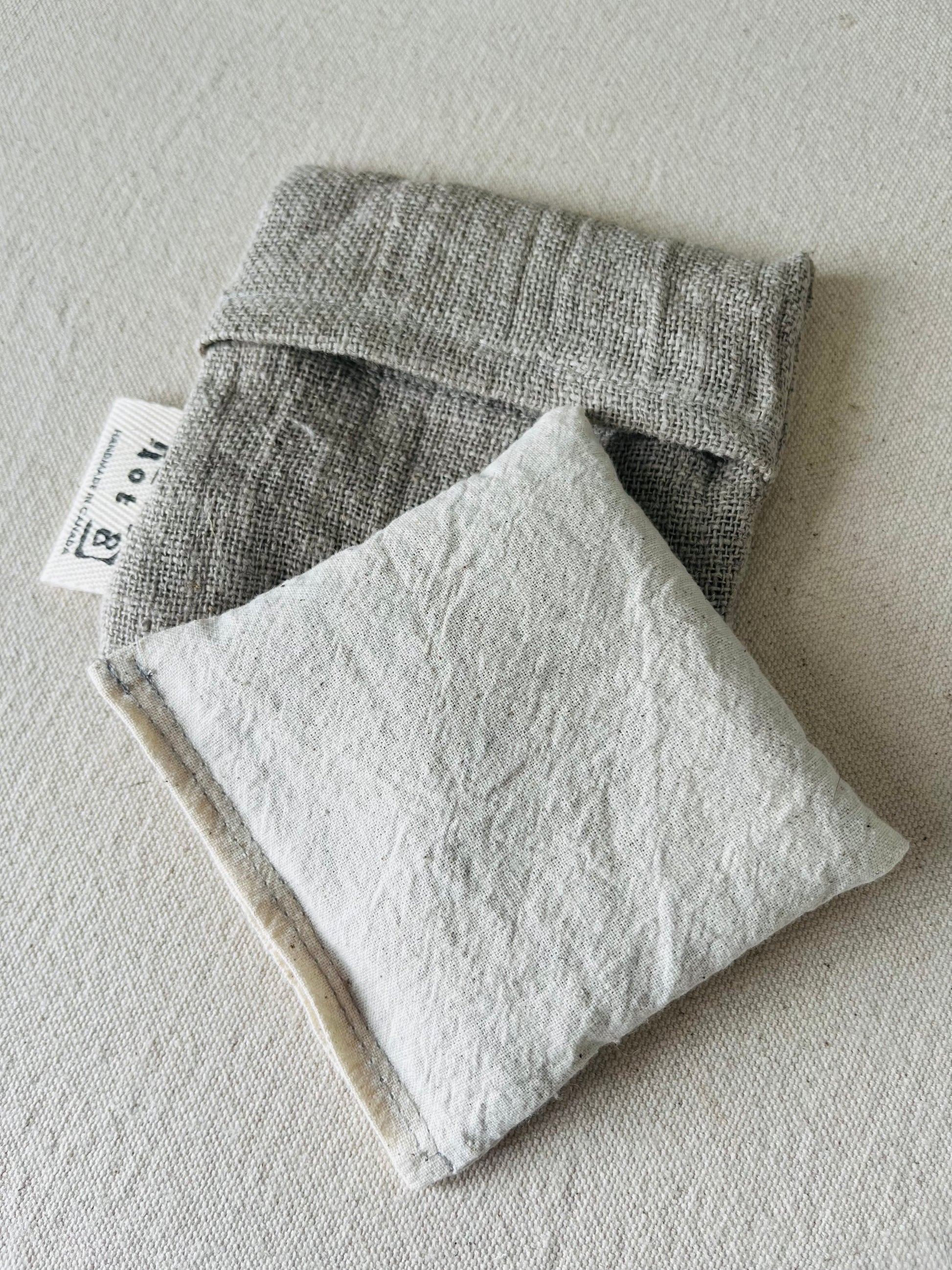 The body of the boo boo bag is cotton muslin in a cream white. It lays atop the linen pouch that protects it when it is in use.