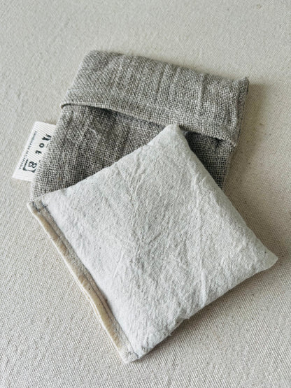 The body of the boo boo bag is cotton muslin in a cream white. It lays atop the linen pouch that protects it when it is in use.