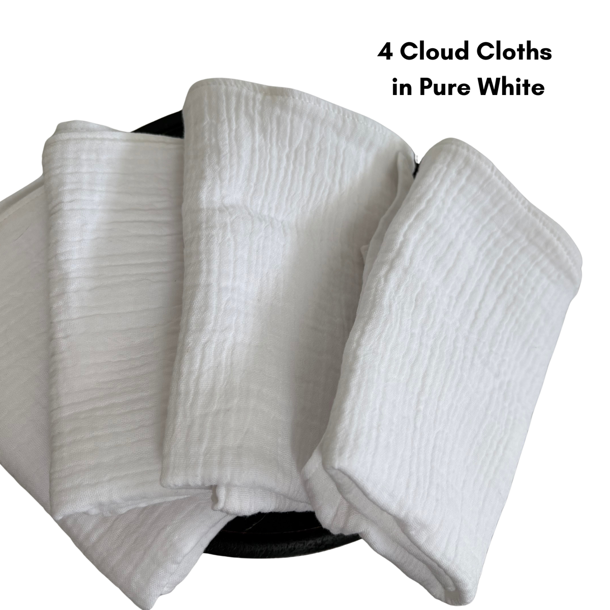 4 cloud cloths in pure white are folded and fanned out on a wooden pedestal