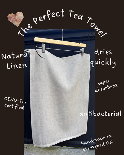 Natural tea towel on a wooden hanger with text highlighting its features against a dark background.