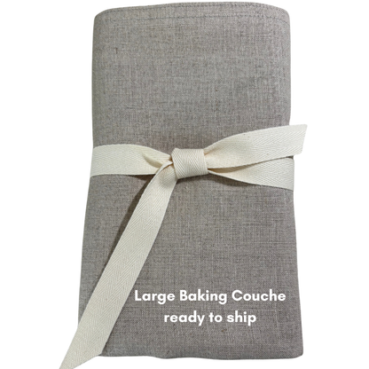 A natural coloured linen baking couche is neatly folded and tied with a natural twill ribbon.
