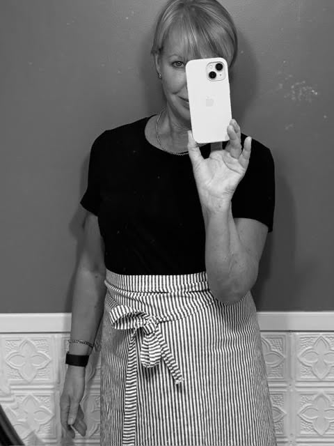 Shawna, the co-owner of Ariel's BnB in Stratford On takes an artsy black and white pic of herself wearing the black and white striped half apron.