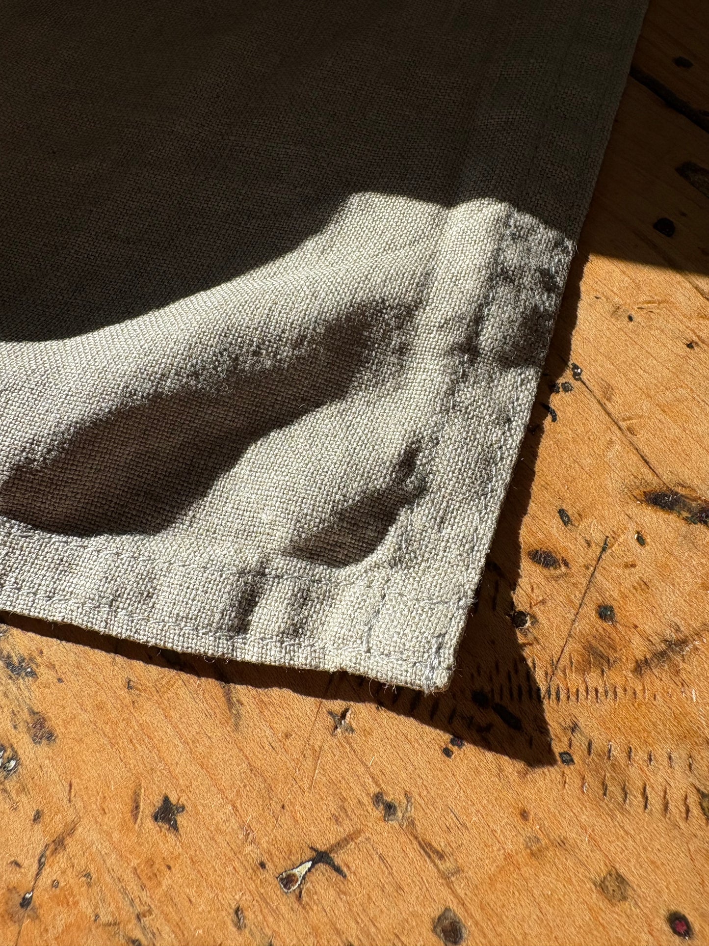 Close-up of a textured linen sample on a wooden surface