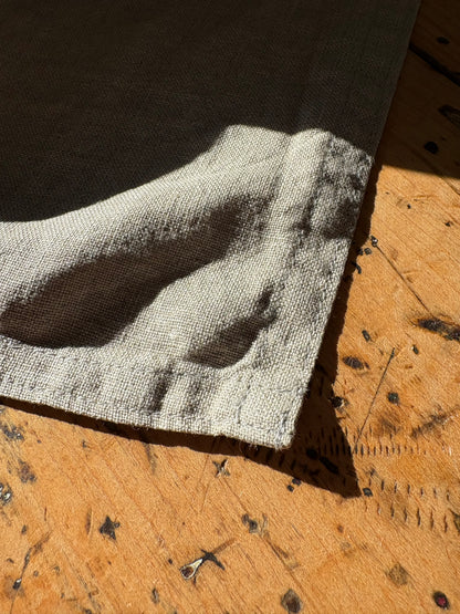 Close-up of a textured linen sample on a wooden surface
