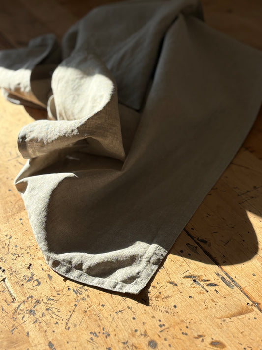 Folded natural tea towel on a wooden surface