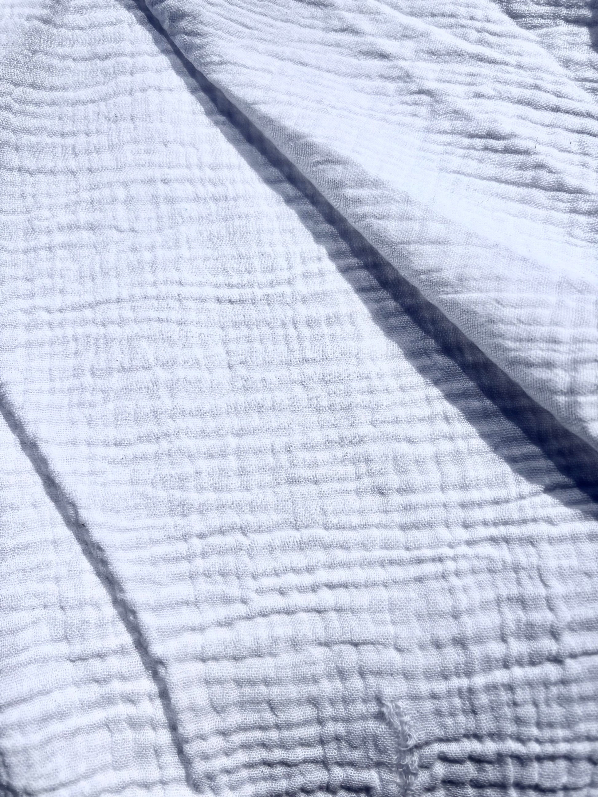 Close-up of textured double-gauze cotton in white. 