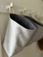 Side view of a grey wool all purpose sack lined with dark grey flannelette hanging from a rail in the foyer.