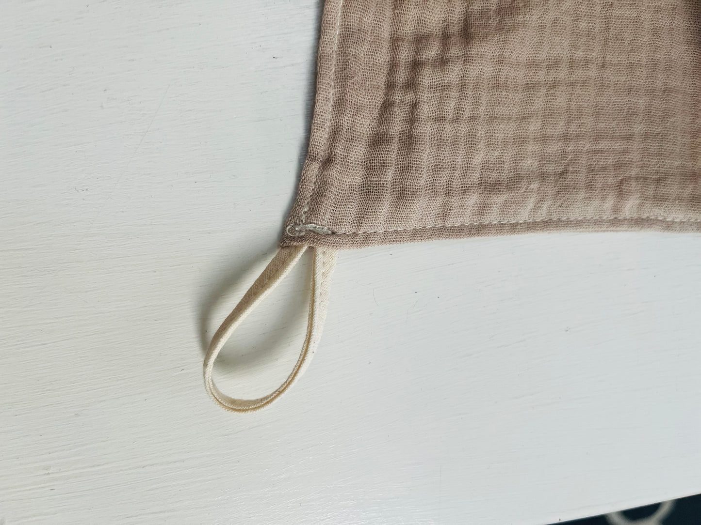 A loop of natural cotton muslin is sewn into the corner of the facecloth. 